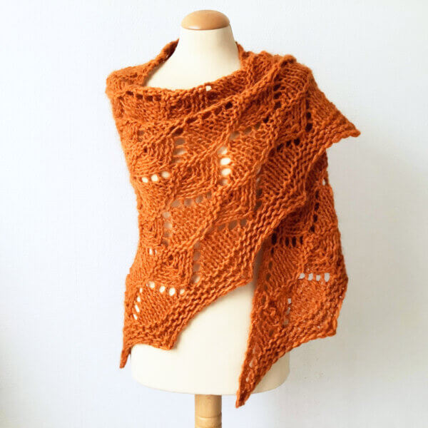 Atomic Tangerine: a bright orange bulky weight knit lace shawl, shown from the front on a mannequin against a white background.