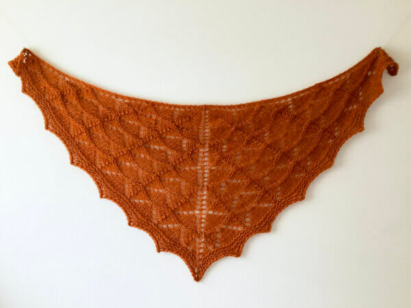 Atomic Tangerine: a bright orange bulky weight knit lace shawl, shown flat against a white background.